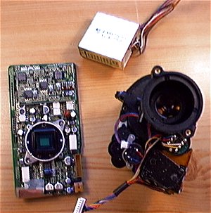 A gauche, la platine CCD, on aperçoit le capteur, le filtre IR, la bride de fixation. A droite, l'objectif vu de l'arrière, avec les moteurs de zoom et map, et le galvanomètre commandant le diaphragme.